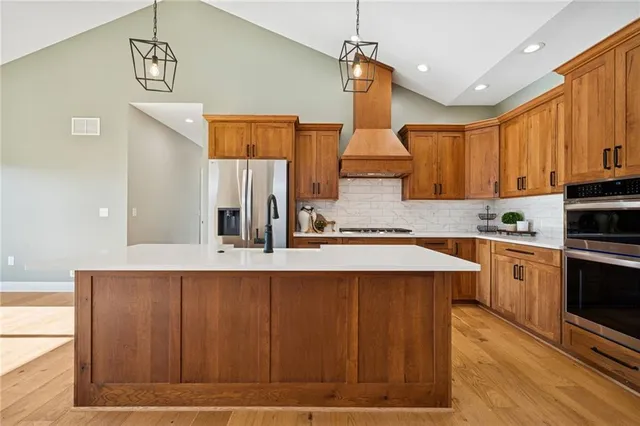 a kitchen with a sink cabinets stainless steel appliances and a window