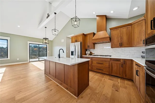 a kitchen with stainless steel appliances granite countertop a sink and wooden cabinets