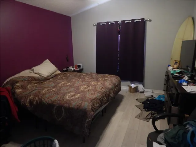 a bedroom with a bed dresser and a flat tv screen