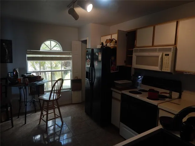 a kitchen with a refrigerator and furniture