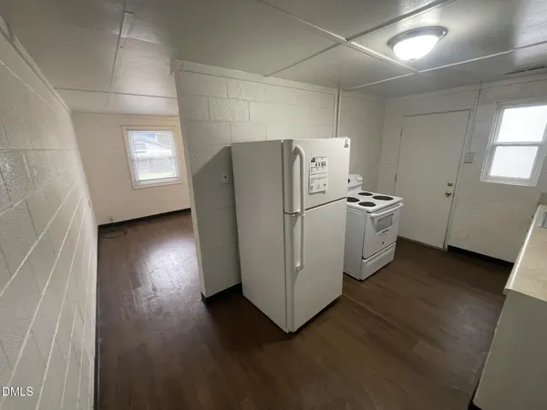 a view of a kitchen with refrigerator and wooden floor