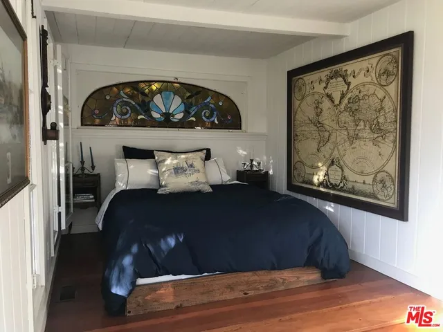 a bedroom with a bed and a painting on the wall