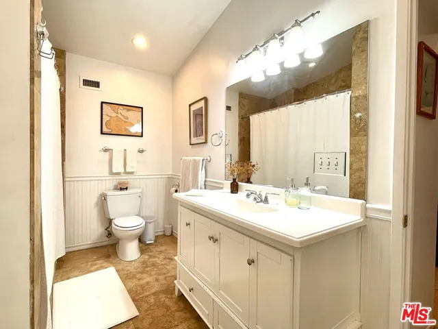a spacious bathroom with a sink a toilet and a mirror