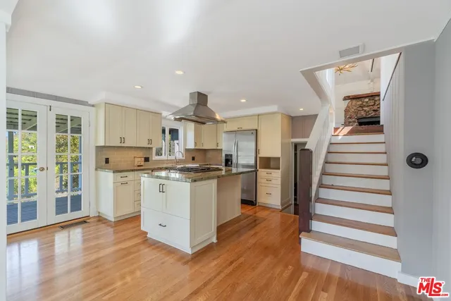 a kitchen with a refrigerator and wooden floor