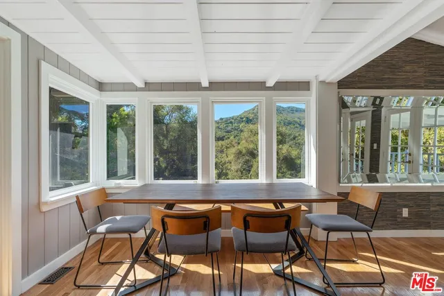 a view of a dining room with furniture large windows and wooden floor