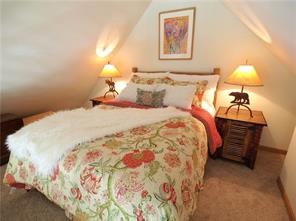 237 South Ridge Street, Unit 6 Breckenridge, CO 80424 - Photo 8 of 16 a bedroom with bed and lamp on dresser