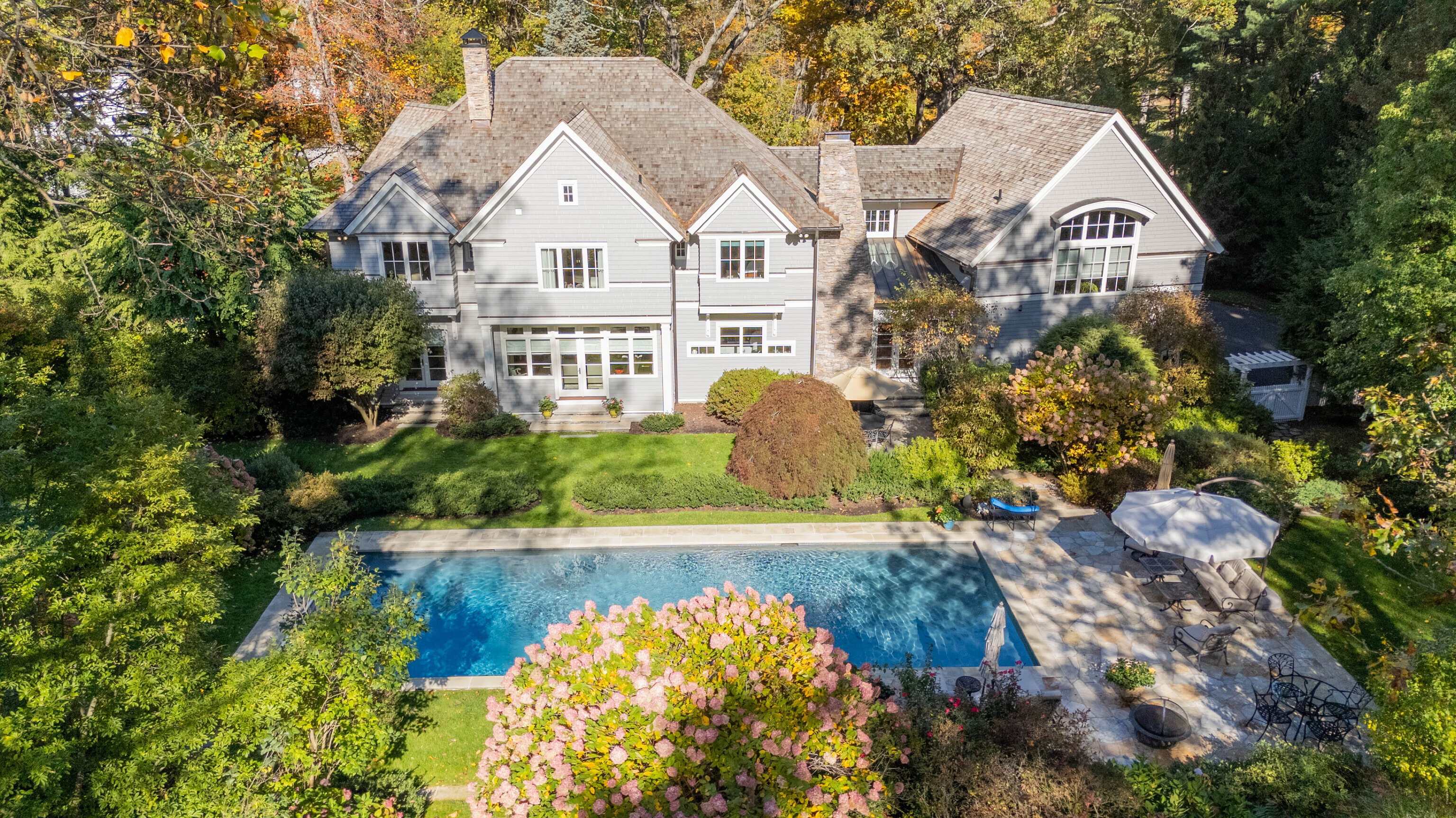 116 Roseville Road Westport, CT 06880 - Photo 2 of 11 a view of a white house with a yard and plants