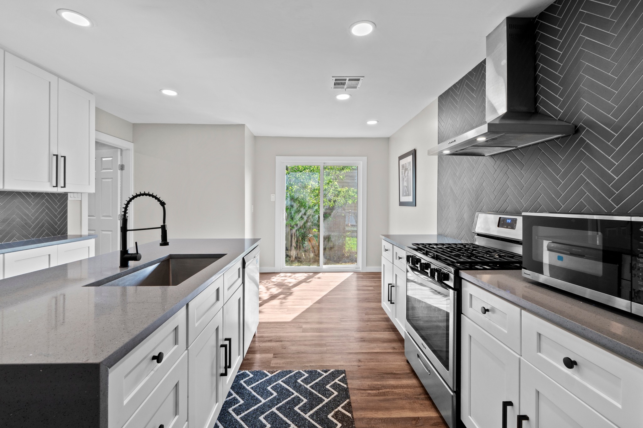 11811 Rotherham Drive Austin, TX 78754 - Photo 10 of 37 Modern kitchen with sleek countertops and stylish herringbone backsplash offers functional design.