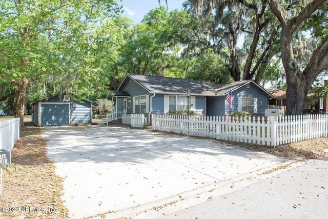a view of a house with a small yard and wooden fence