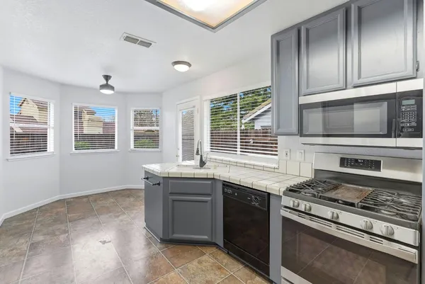 a kitchen with stainless steel appliances granite countertop a stove and a microwave