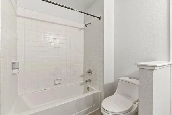 a white toilet and tub sitting next to a bathroom sink