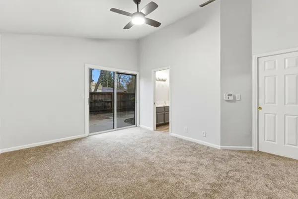 an empty room with fan and windows