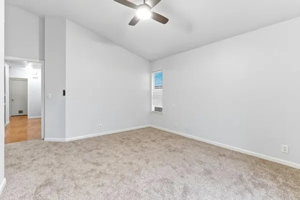 an empty room with closet and windows