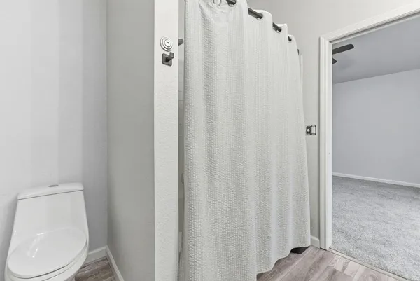 a white toilet and shower curtain