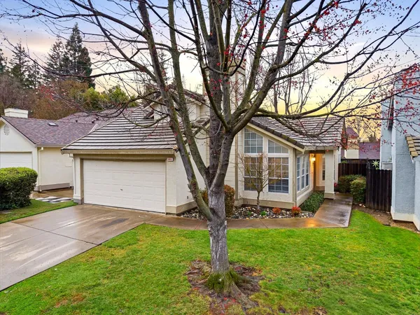 a front view of a house with a yard and trees