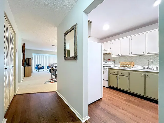 a kitchen with a refrigerator and white cabinets