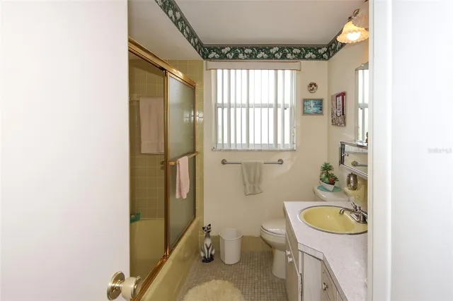 a bathroom with a granite countertop toilet sink and mirror