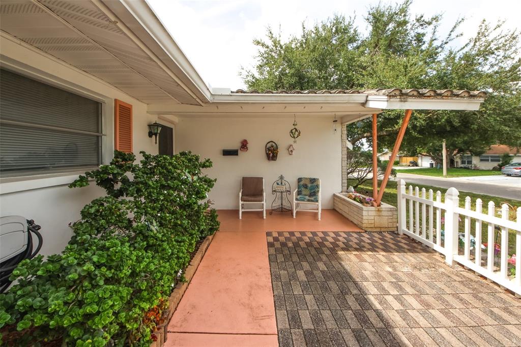 10638 Oak Hill Drive Port Richey, FL 34668 - Photo 4 of 29 a view of a patio with table and chairs potted plants with wooden floor