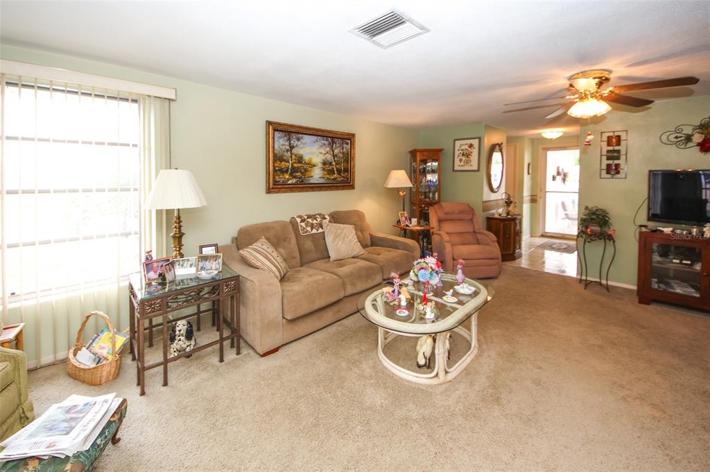 10638 Oak Hill Drive Port Richey, FL 34668 - Photo 7 of 29 a living room with furniture and a flat screen tv
