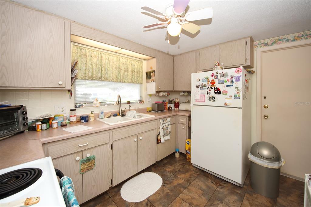 10638 Oak Hill Drive Port Richey, FL 34668 - Photo 9 of 29 a kitchen with sink a refrigerator and a stove