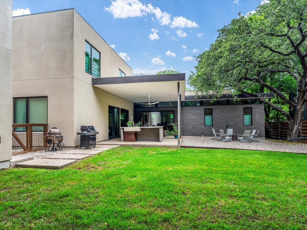 1703 Dexter Street Austin, TX 78704 - Photo 29 of 34 Back of property with ceiling fan, a patio area, and stucco siding