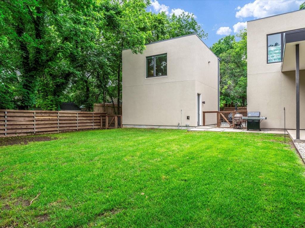 1703 Dexter Street Austin, TX 78704 - Photo 30 of 34 Rear view of house with a fenced backyard, a patio, and stucco siding