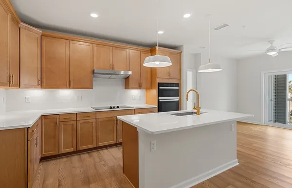 a kitchen with stainless steel appliances granite countertop a sink a stove and a wooden floors
