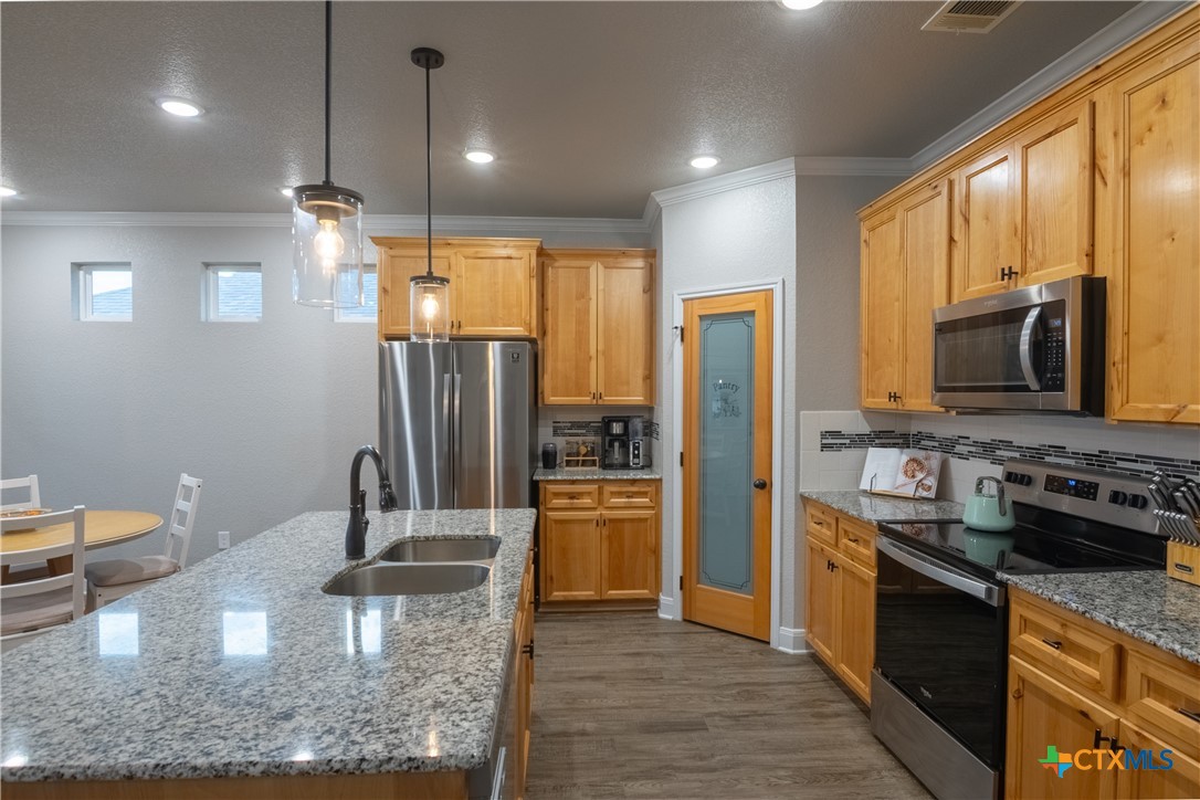 7909 McCulloch Road Temple, TX 76502 - Photo 20 of 46 a kitchen with stainless steel appliances granite countertop a sink a stove and a refrigerator