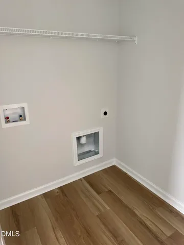 a view of a room with wooden floor and white walls