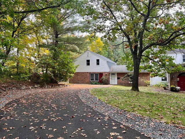 a front view of house with yard and trees around