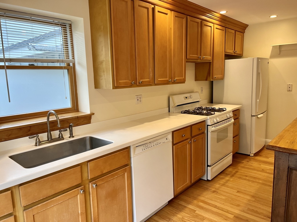 46 Auburndale Avenue, Unit 46 Newton, MA 02465 - Photo 4 of 17 a kitchen with stainless steel appliances granite countertop a refrigerator a sink dishwasher and white cabinets with wooden floor