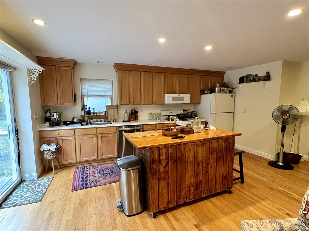 46 Auburndale Avenue, Unit 46 Newton, MA 02465 - Photo 5 of 17 a kitchen with stainless steel appliances granite countertop a stove a sink dishwasher and a refrigerator with wooden floor