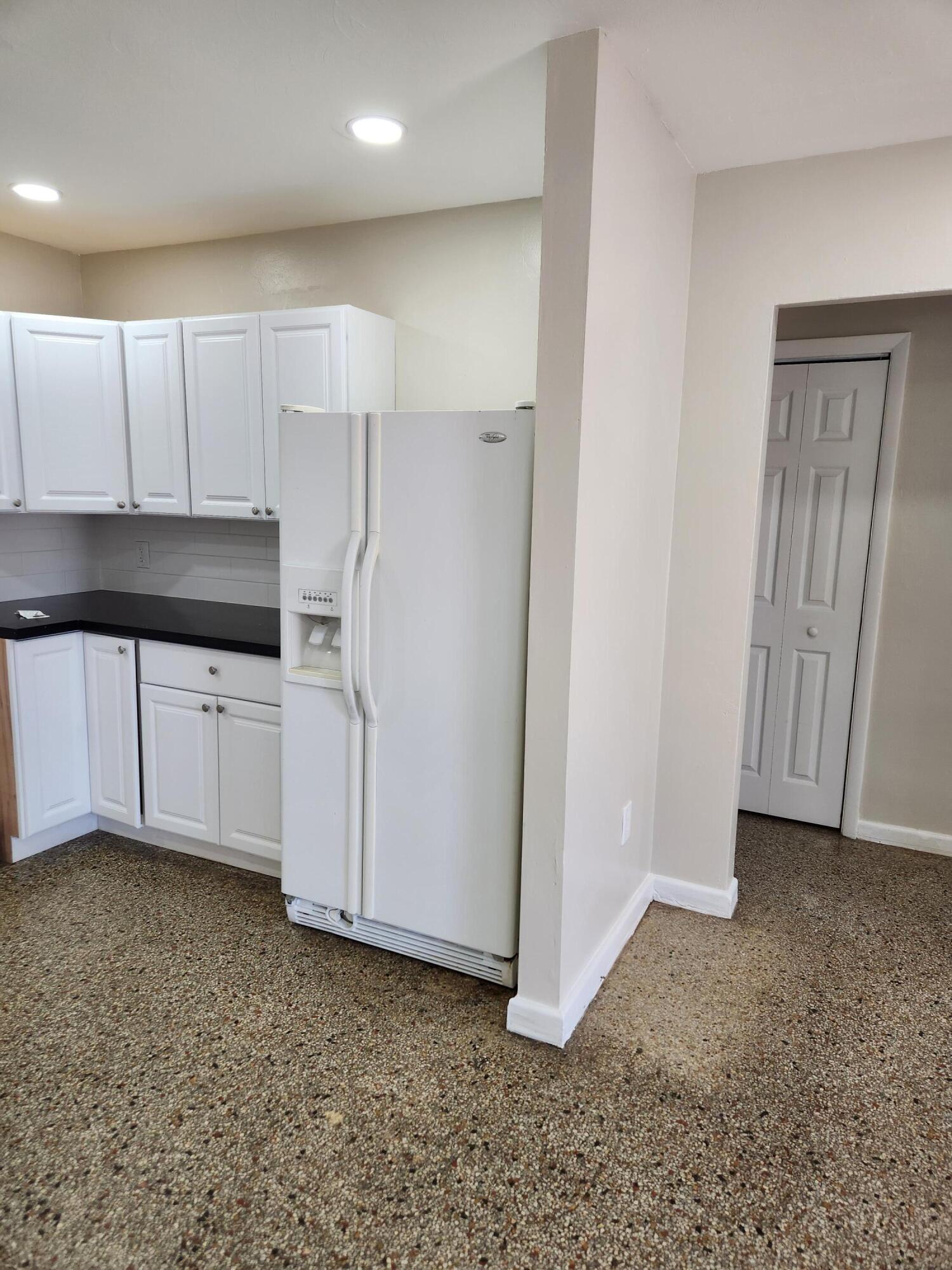 136 West 34th Street, Unit A Riviera Beach, FL 33404 - Photo 2 of 12 a kitchen with white cabinets and refrigerator