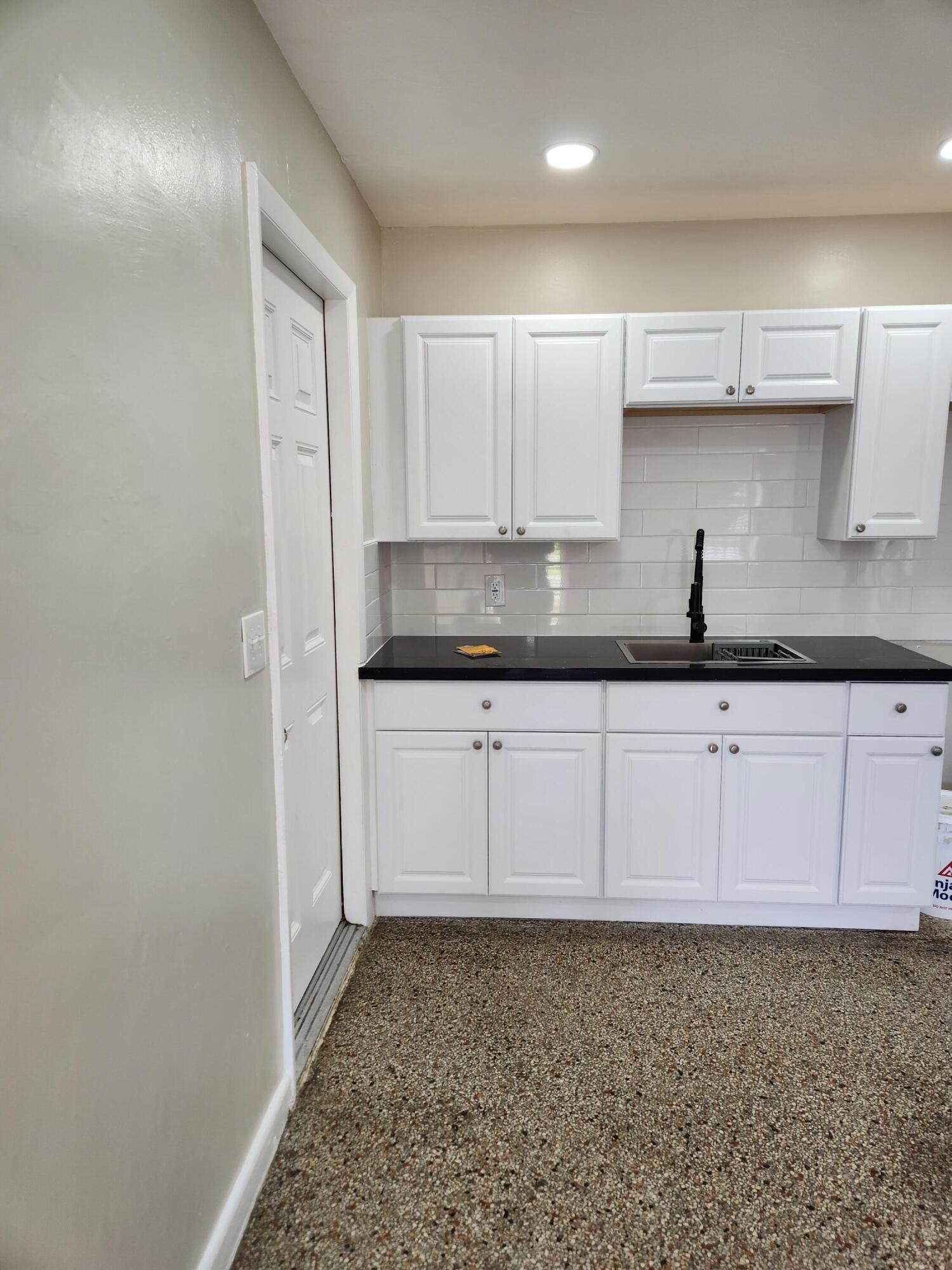 136 West 34th Street, Unit A Riviera Beach, FL 33404 - Photo 5 of 12 a kitchen with granite countertop a sink and cabinets