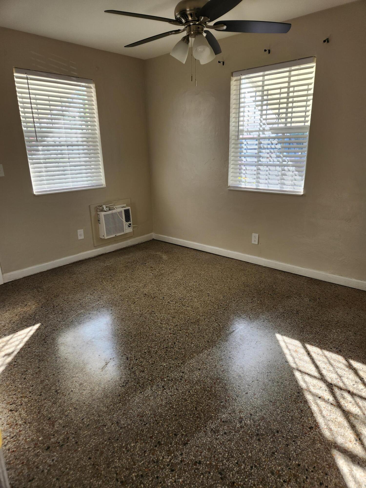 136 West 34th Street, Unit A Riviera Beach, FL 33404 - Photo 6 of 12 an empty room with wooden floor fan and windows