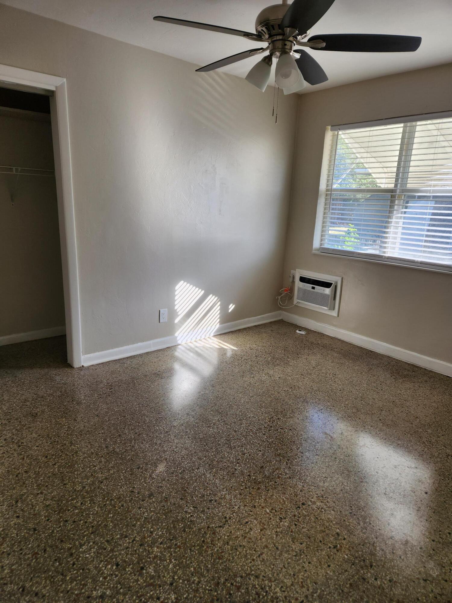 136 West 34th Street, Unit A Riviera Beach, FL 33404 - Photo 7 of 12 an empty room with windows and fan