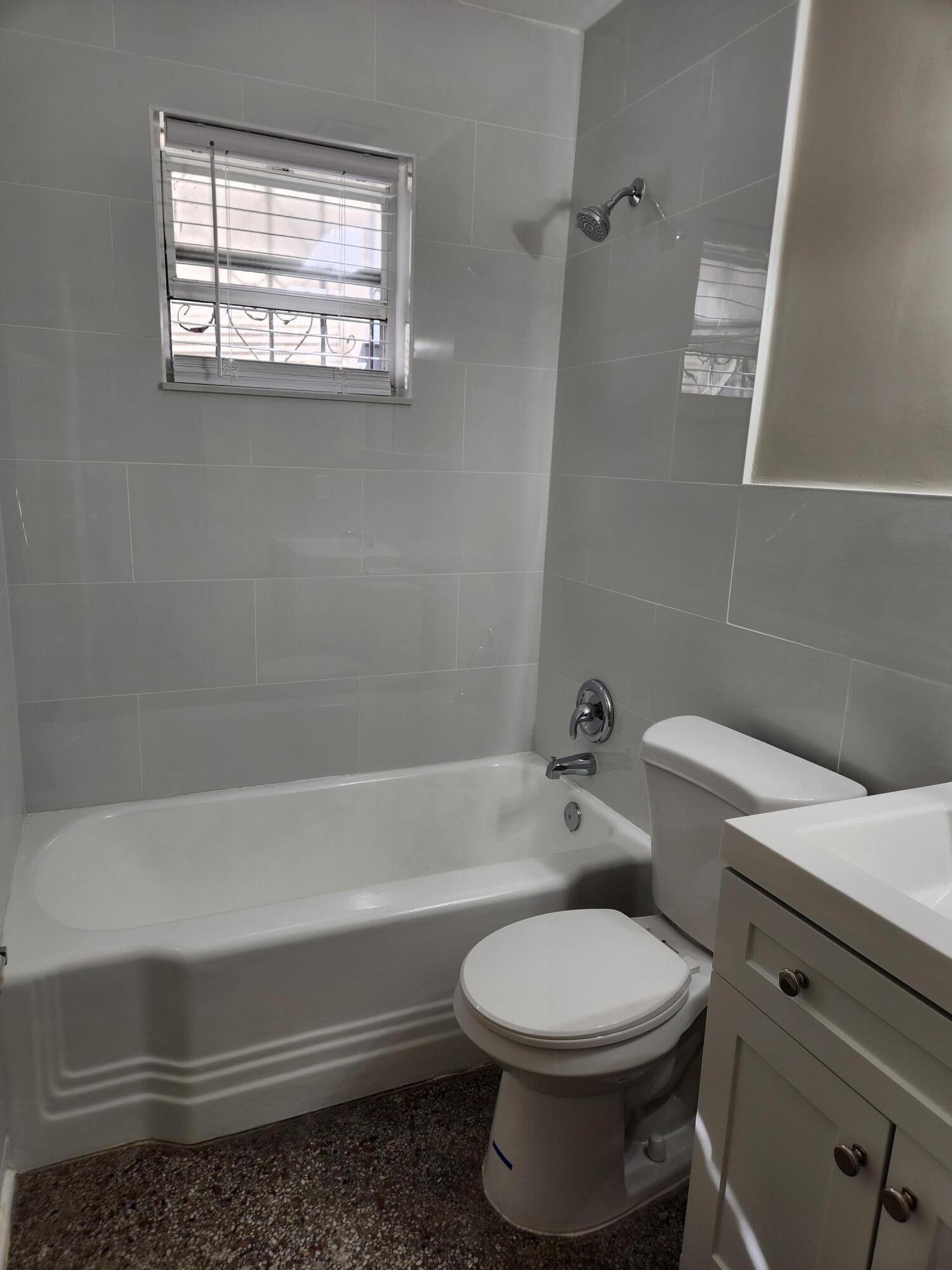 136 West 34th Street, Unit A Riviera Beach, FL 33404 - Photo 8 of 12 a bathroom with a toilet a sink and bathtub