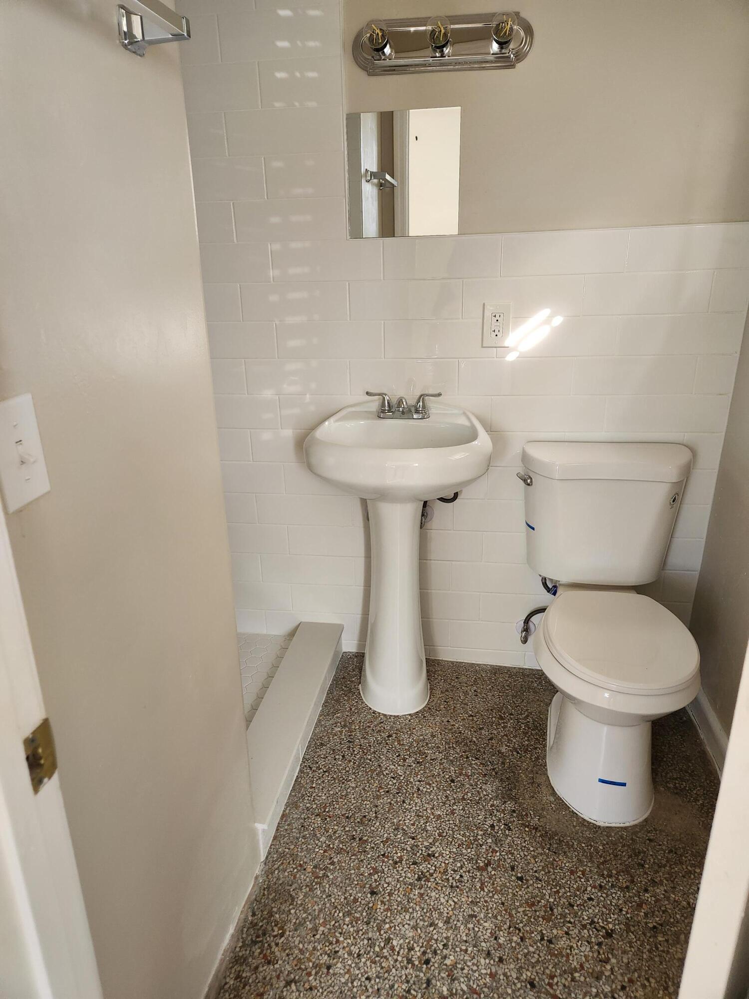 136 West 34th Street, Unit A Riviera Beach, FL 33404 - Photo 9 of 12 a bathroom with a sink toilet and a mirror