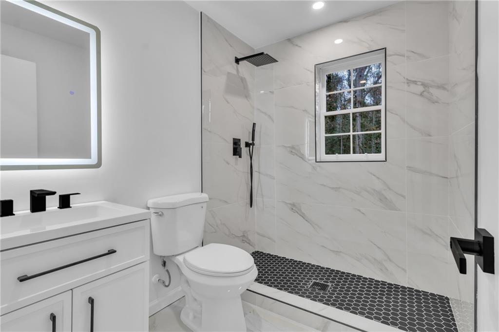 3296 Columbia Woods Drive Decatur, GA 30032 - Photo 30 of 47 a bathroom with a sink toilet a shower and a mirror