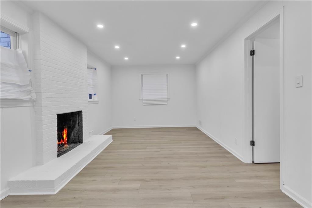 3296 Columbia Woods Drive Decatur, GA 30032 - Photo 32 of 47 an empty room with wooden floor fireplace and windows