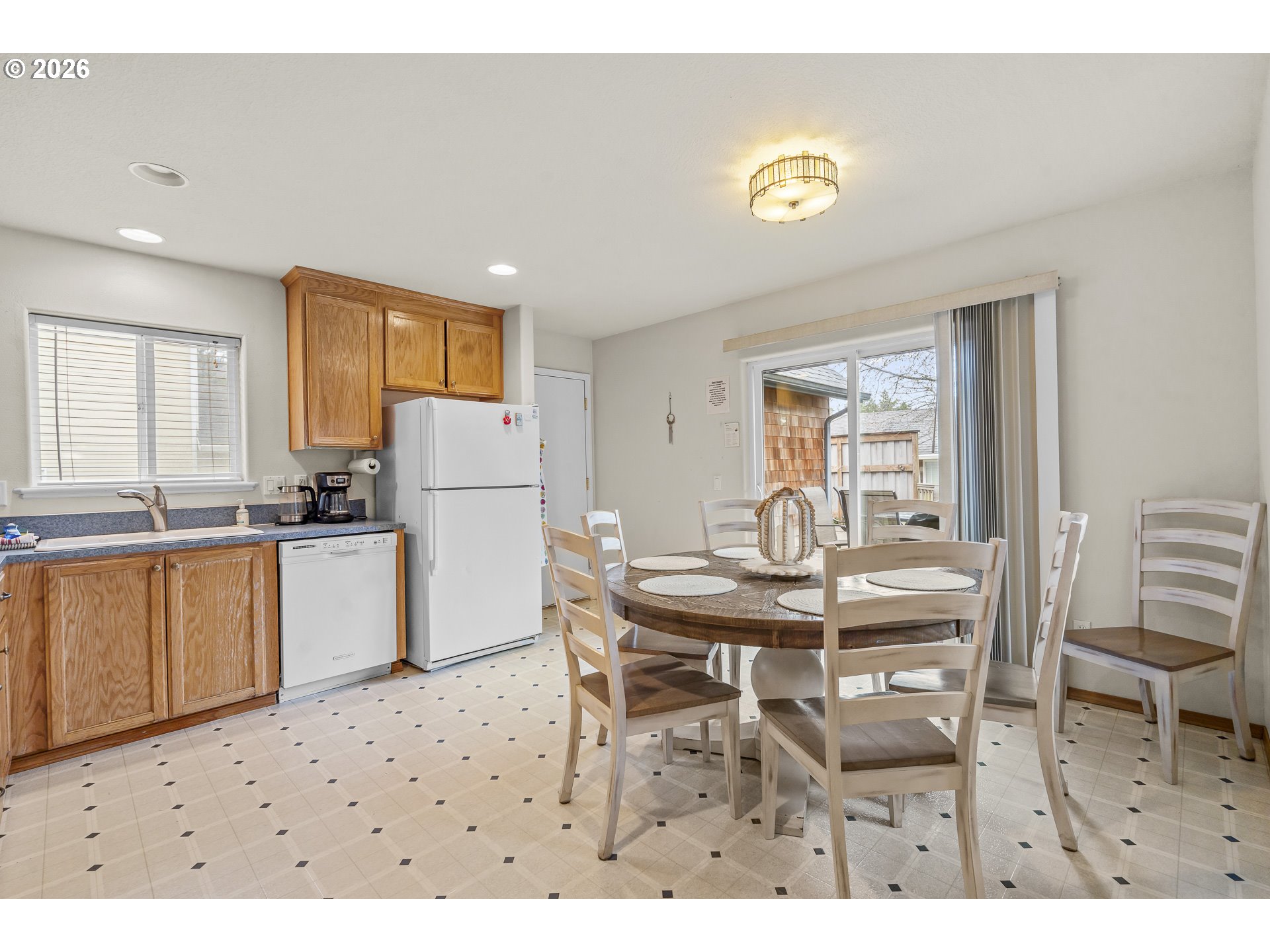 7850 Pine Beach Loop Rockaway Beach, OR 97136 - Photo 11 of 33 a kitchen with a table chairs and a refrigerator