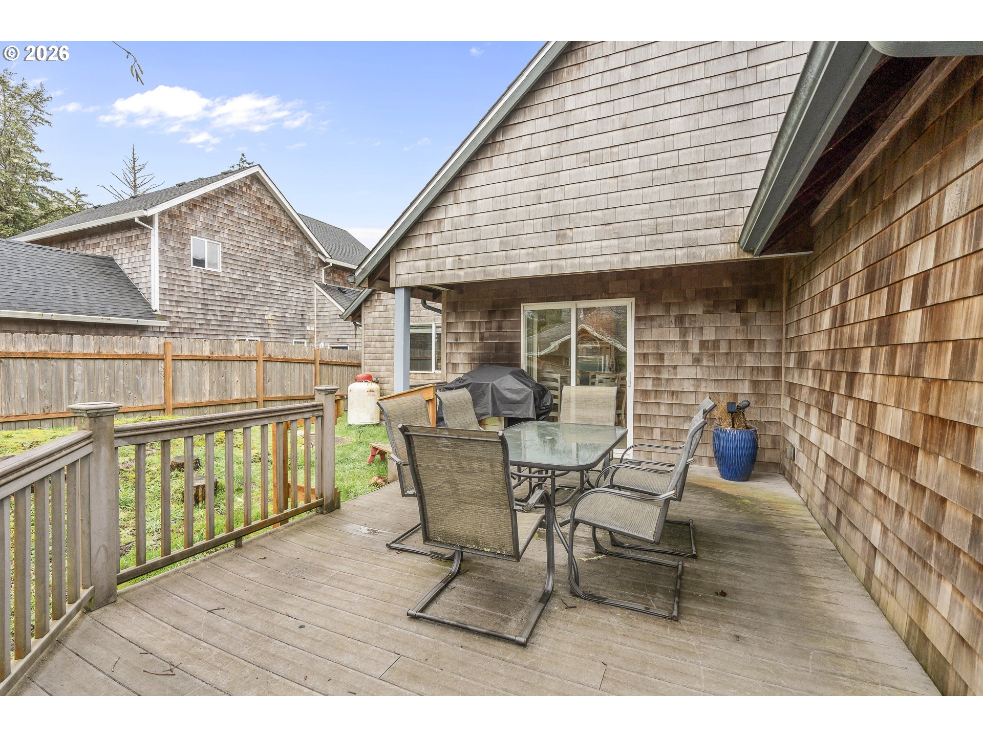 7850 Pine Beach Loop Rockaway Beach, OR 97136 - Photo 24 of 33 a view of a deck with table and chairs and wooden floor