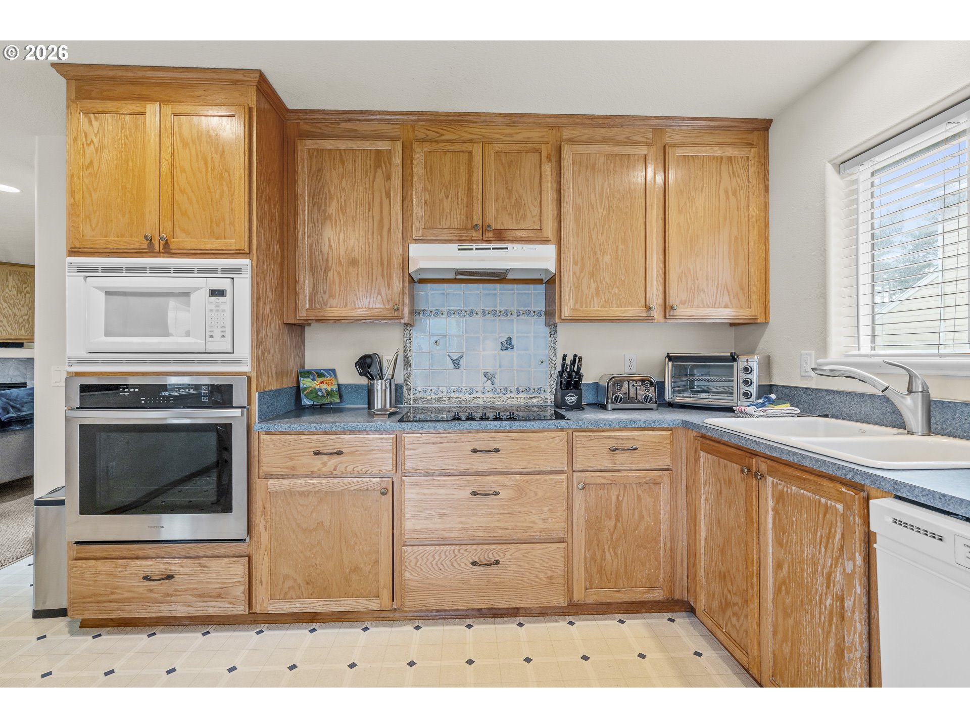 7850 Pine Beach Loop Rockaway Beach, OR 97136 - Photo 7 of 33 a kitchen with granite countertop a stove a sink and a microwave