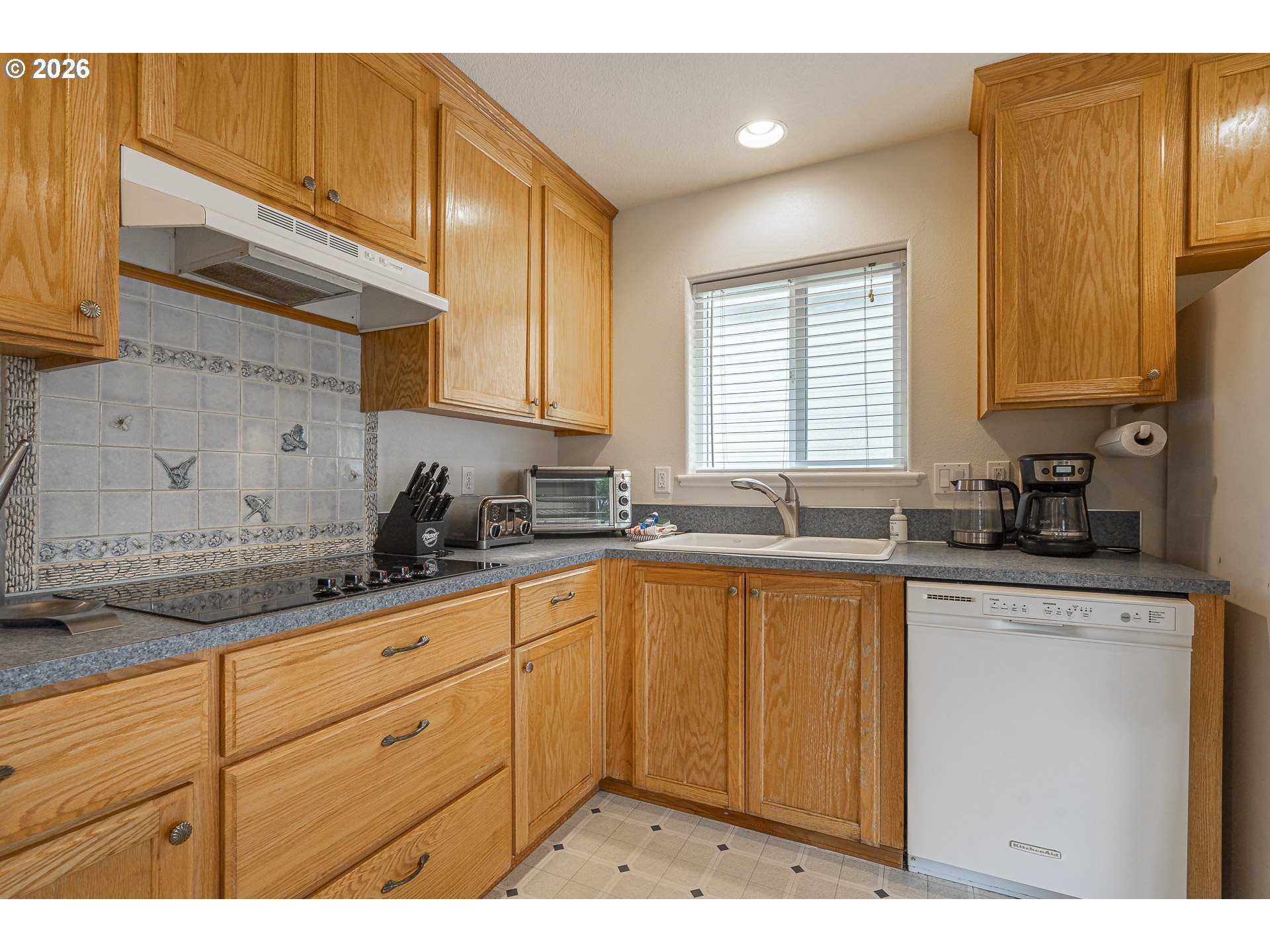 7850 Pine Beach Loop Rockaway Beach, OR 97136 - Photo 8 of 33 a kitchen with granite countertop stainless steel appliances a sink window and cabinets