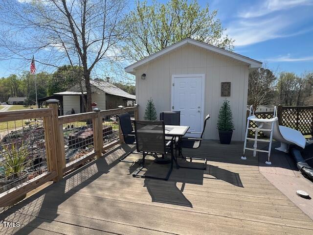 663 Fleming Road Coats, NC 27521 - Photo 23 of 42 a view of a patio with table and chairs with wooden floor and fence