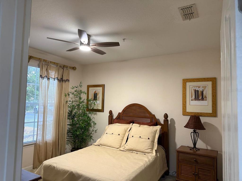 12843 Madison Pointe Circle, Unit 107 Orlando, FL 32821 - Photo 13 of 26 a bedroom with a bed and a chandelier