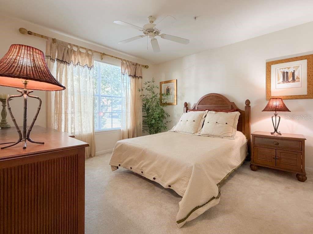12843 Madison Pointe Circle, Unit 107 Orlando, FL 32821 - Photo 14 of 26 a bedroom with a bed dresser and a window