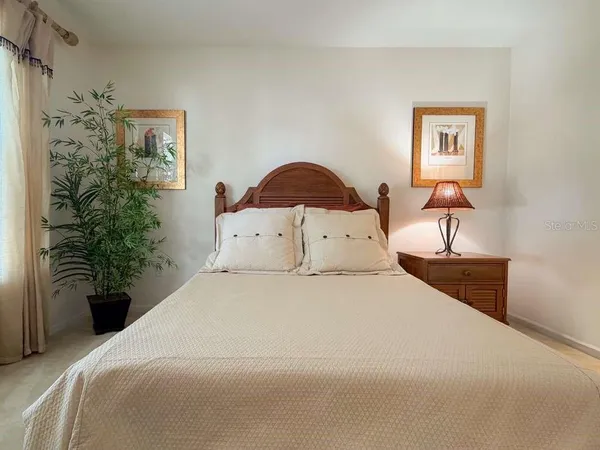 a bedroom with a bed and a potted plant