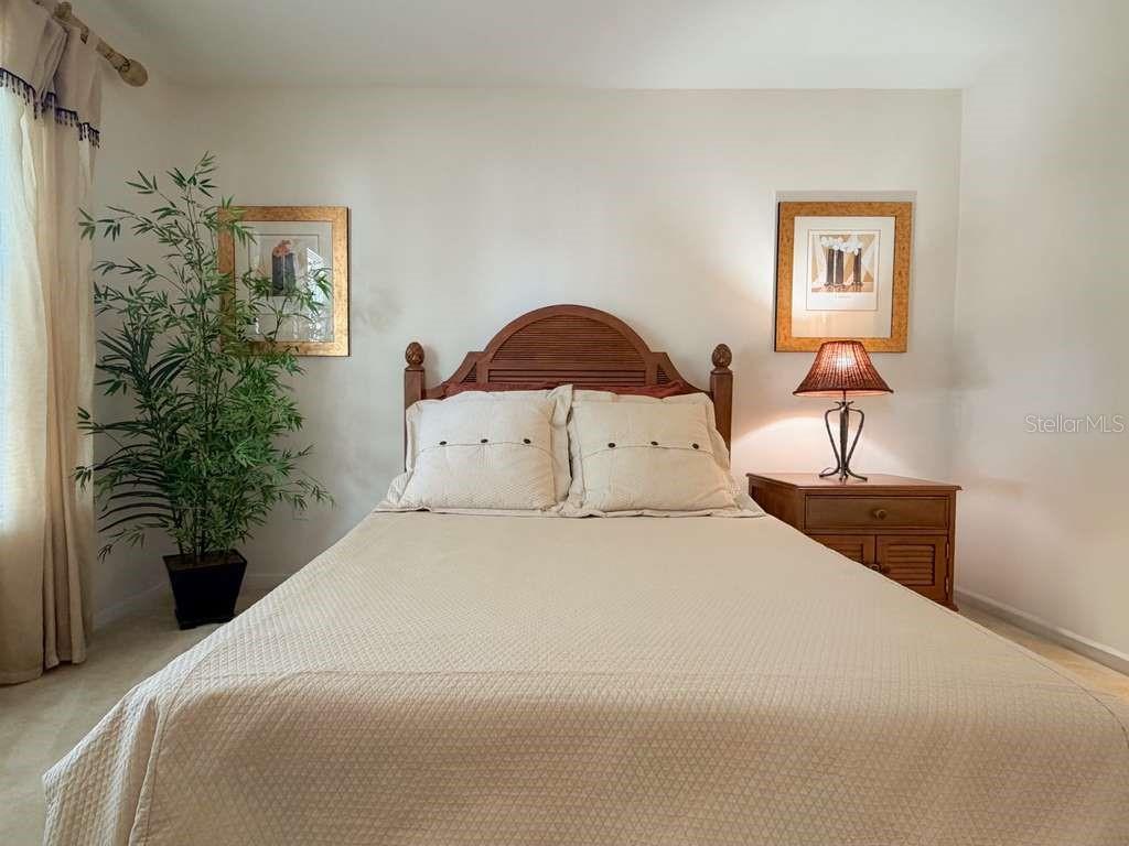 12843 Madison Pointe Circle, Unit 107 Orlando, FL 32821 - Photo 15 of 26 a bedroom with a bed and a potted plant
