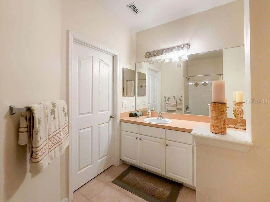 12843 Madison Pointe Circle, Unit 107 Orlando, FL 32821 - Photo 17 of 26 a spacious bathroom with a granite countertop sink and a mirror